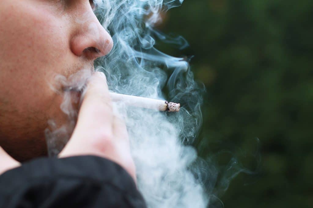 close-up photo of a man smoking a cigarette, the example used in social dissonance theory