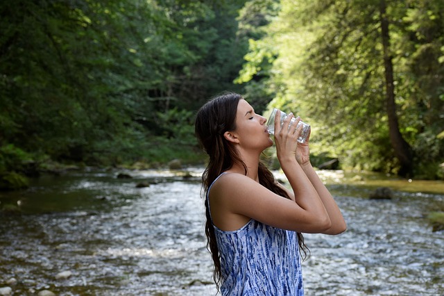 a woman drinking a glass of water which can help cope with selective attention span