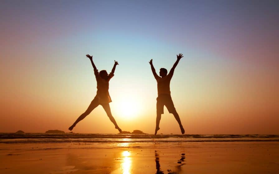 two people jumping and learning how to get rid of negative energy