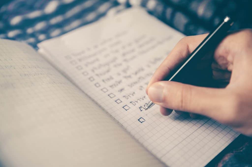 a man writing his to do list and prioritizing the most important tasks first